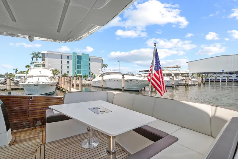 Good Vibes Yacht Photos Pics 2022 Galeon 470 Sky yacht docked, featuring a spacious deck with seating and an American flag.