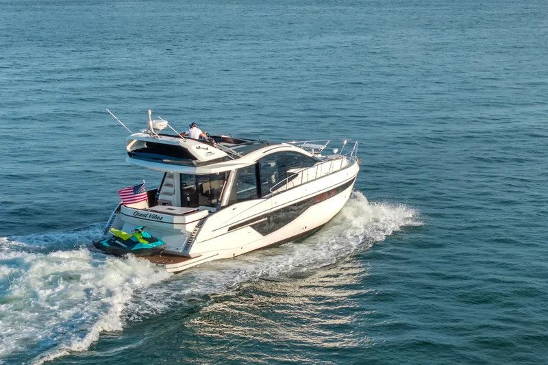 Good Vibes Yacht Photos Pics 2022 Galeon 470 Sky yacht cruising on open water with American flag.