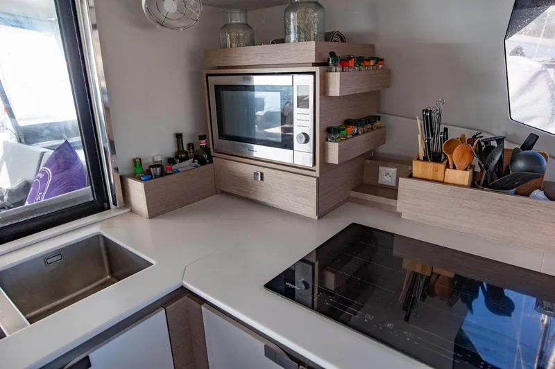 Spirit Of Ecstacy Yacht Photos Pics Modern kitchen in 2023 Fountaine Pajot Tanna 47 yacht with microwave and induction cooktop.
