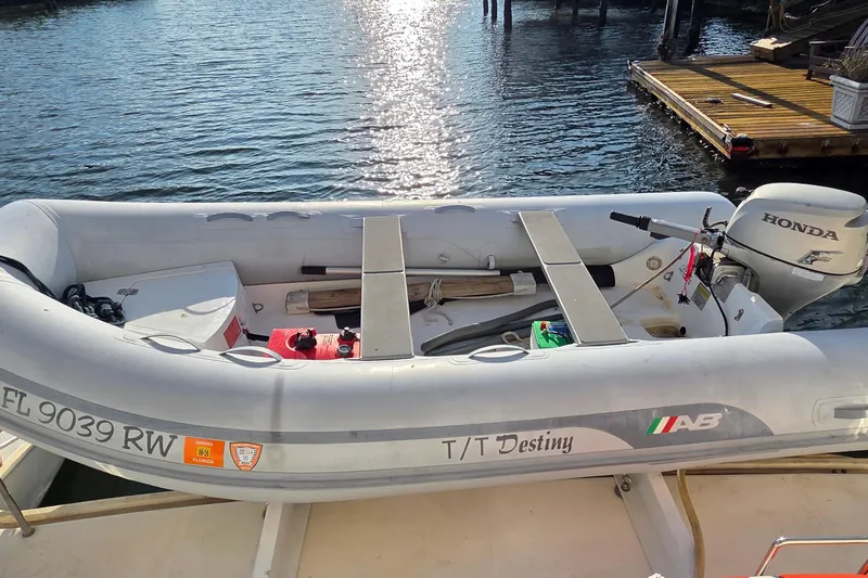 Beshert Yacht Photos Pics Inflatable boat with Honda motor docked on water, labeled "T/T Destiny," Leopard 47, 2004 model.