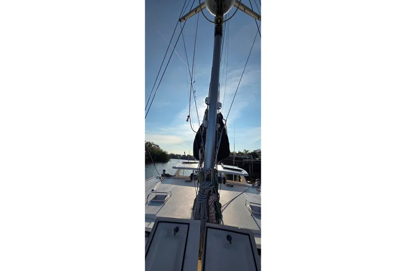 Beshert Yacht Photos Pics 2004 Leopard 47 catamaran on calm water, showcasing mast and deck under clear sky.