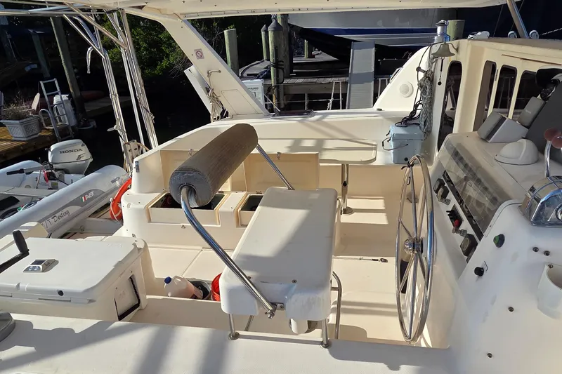 Beshert Yacht Photos Pics 2004 Leopard 47 yacht cockpit with steering wheel and seating area.