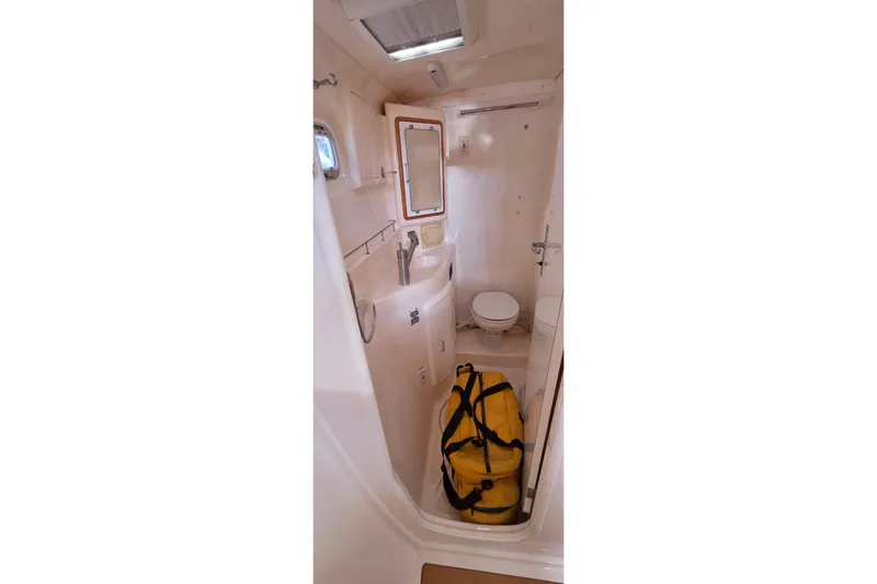 Beshert Yacht Photos Pics Bathroom interior of 2004 Leopard 47 yacht with yellow duffel bag.