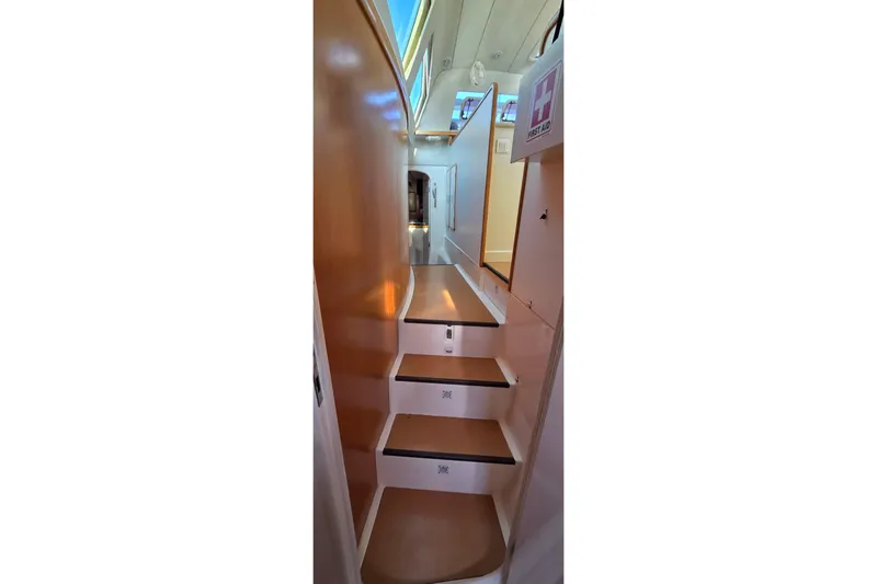 Beshert Yacht Photos Pics Interior stairs of 2004 Leopard 47 yacht, featuring sleek design and first aid kit.