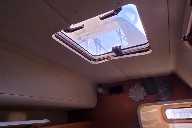 Beshert Yacht Photos Pics Interior view of a 2004 Leopard 47 yacht with an open ceiling hatch.