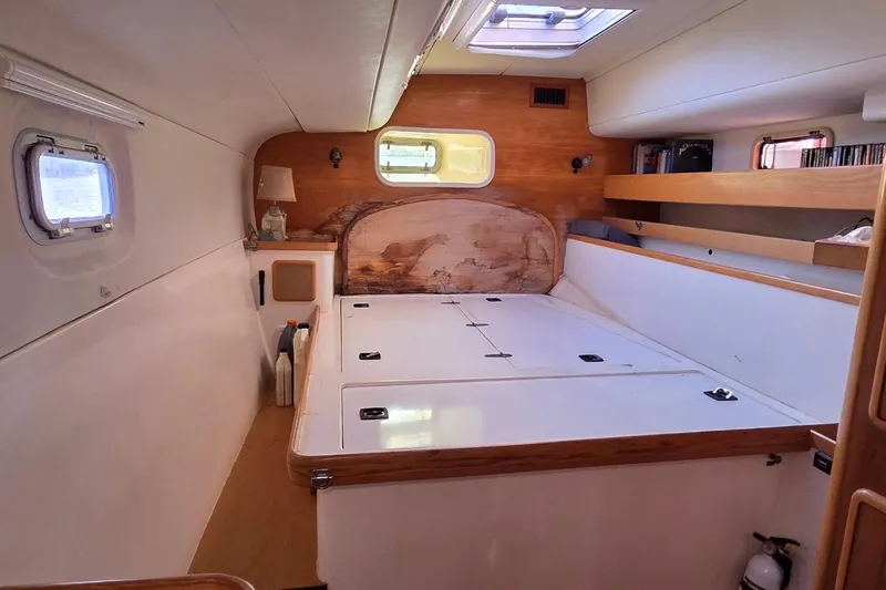 Beshert Yacht Photos Pics Interior of a 2004 Leopard 47 catamaran cabin with wooden accents and storage space.