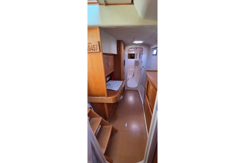 Beshert Yacht Photos Pics Interior of 2004 Leopard 47 yacht, featuring wooden cabinetry and compact design.