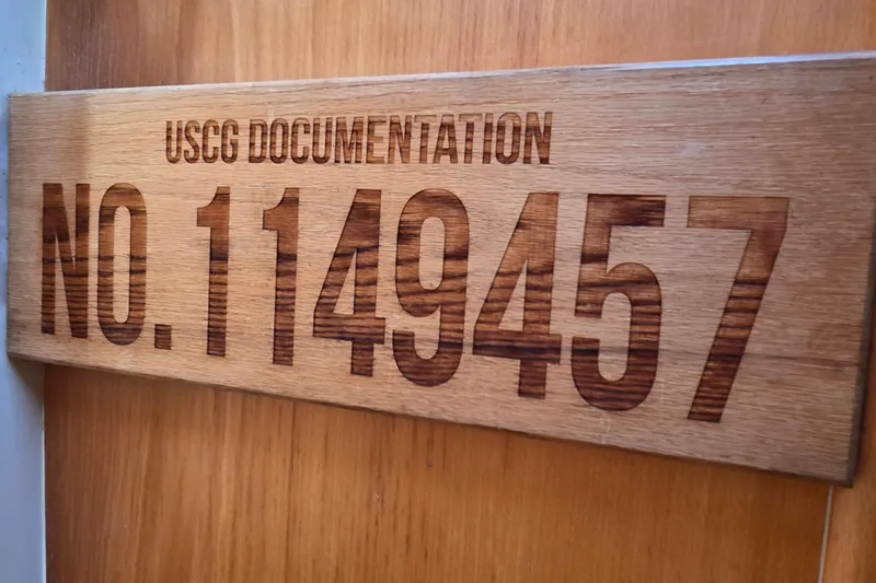 Beshert Yacht Photos Pics USCG documentation plaque with number 1149457 on wooden background.