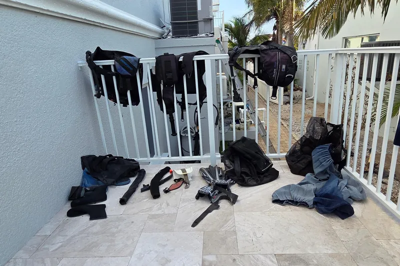Beshert Yacht Photos Pics Diving gear drying on a balcony, including wetsuits and fins, near a Leopard 47 catamaran.