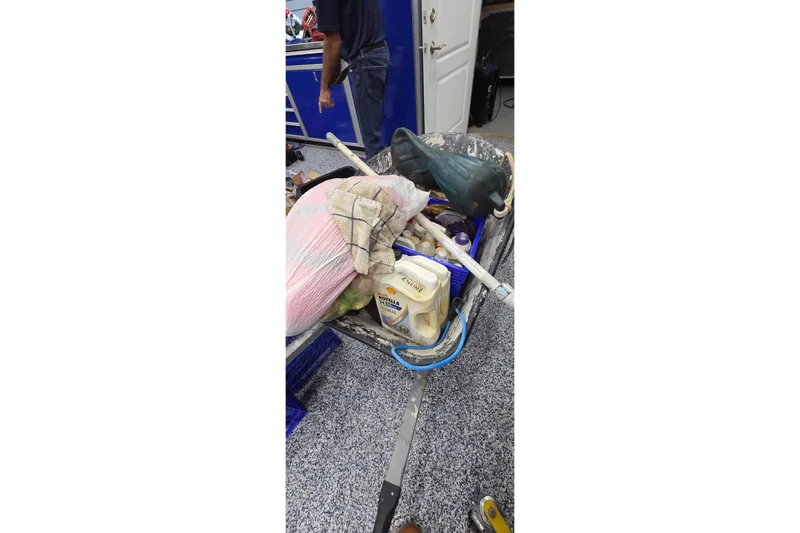 Beshert Yacht Photos Pics A cluttered workspace with tools, containers, and a person in a garage setting.