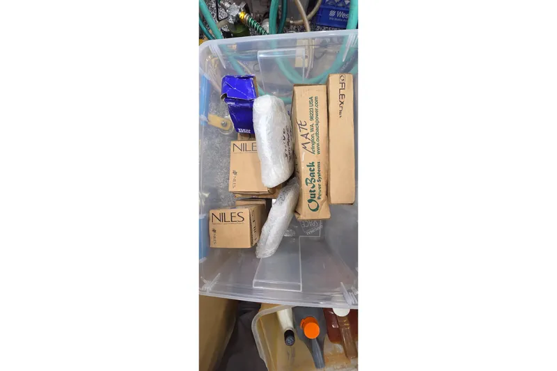 Beshert Yacht Photos Pics Plastic container with various boxed items and wrapped packages, Leopard 47, 2004 model.