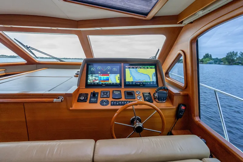 Carole Lyn Yacht Photos Pics 2018 Palm Beach Motor Yachts PB55 helm with navigation screens and wooden steering wheel.