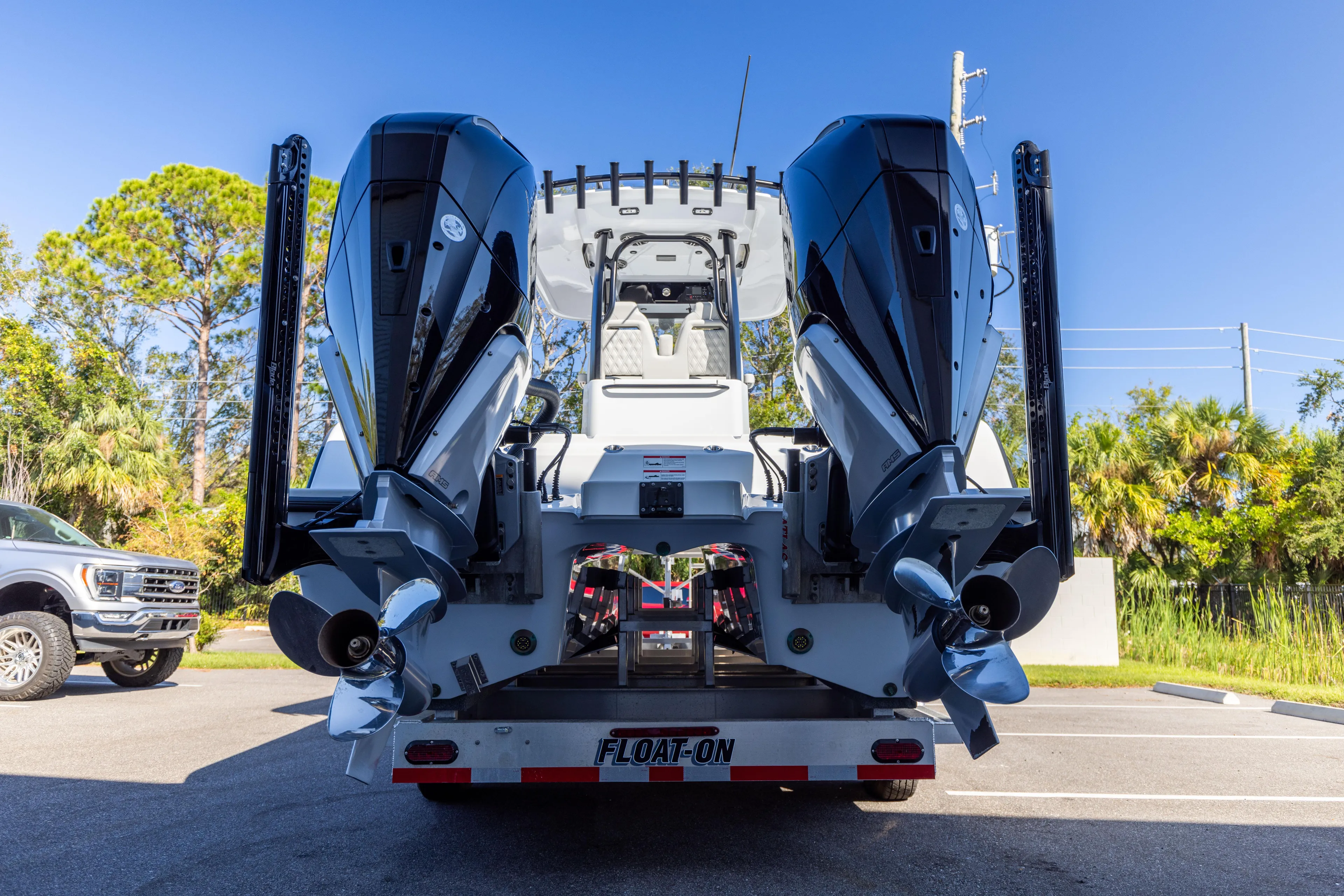  Yacht Photos Pics 2024 Freeman 28 boat with dual engines on a trailer, parked outdoors.
