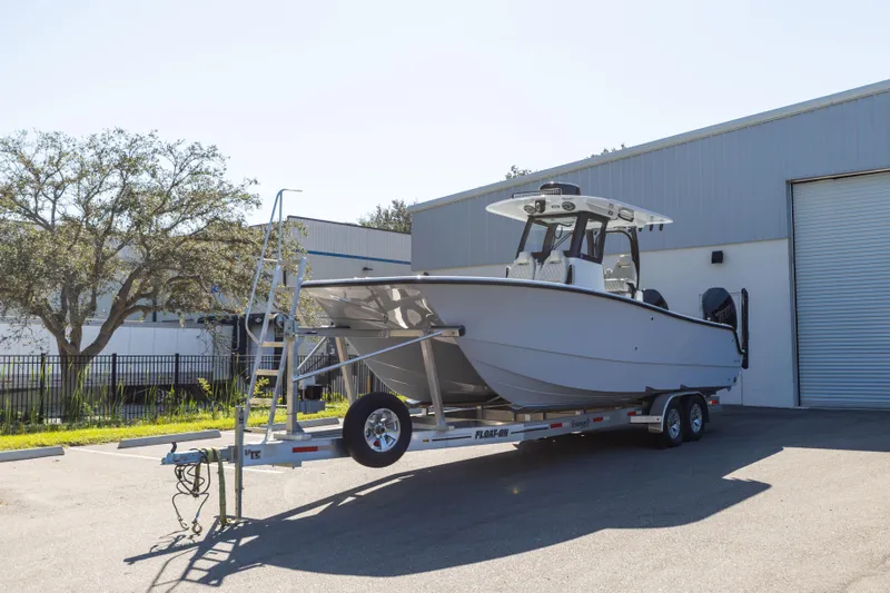  Yacht Photos Pics 2024 Freeman 28 boat on trailer outside industrial building.
