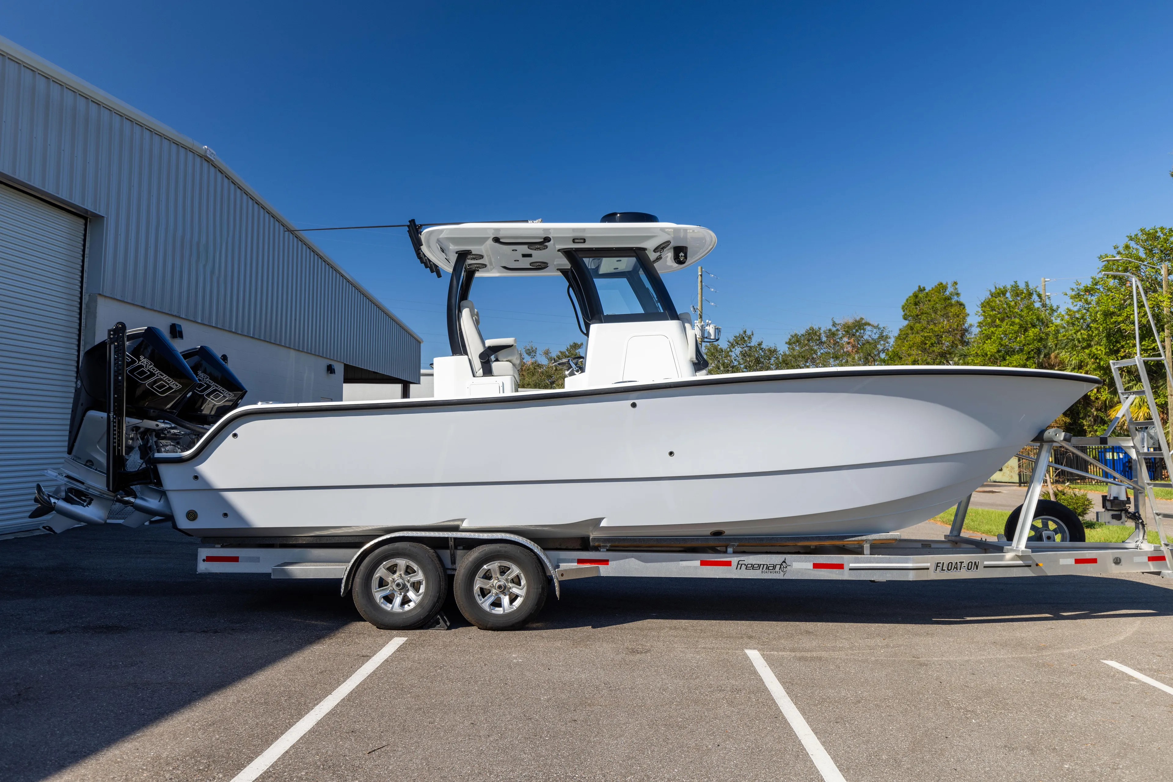  Yacht Photos Pics 2024 Freeman 28 boat on trailer, parked outside a warehouse.