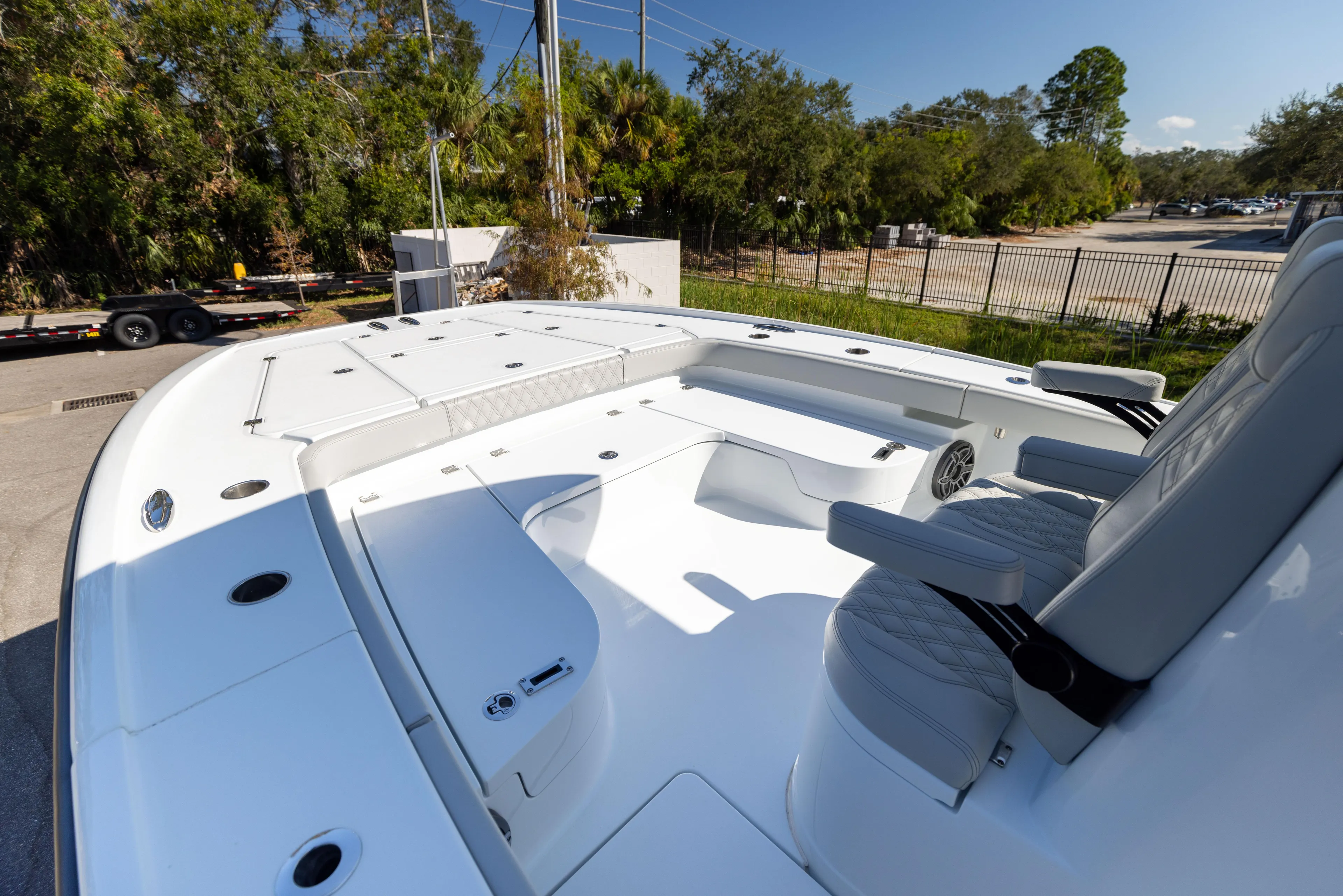  Yacht Photos Pics 2024 Freeman 28 boat deck with seating, surrounded by trees and a fence.