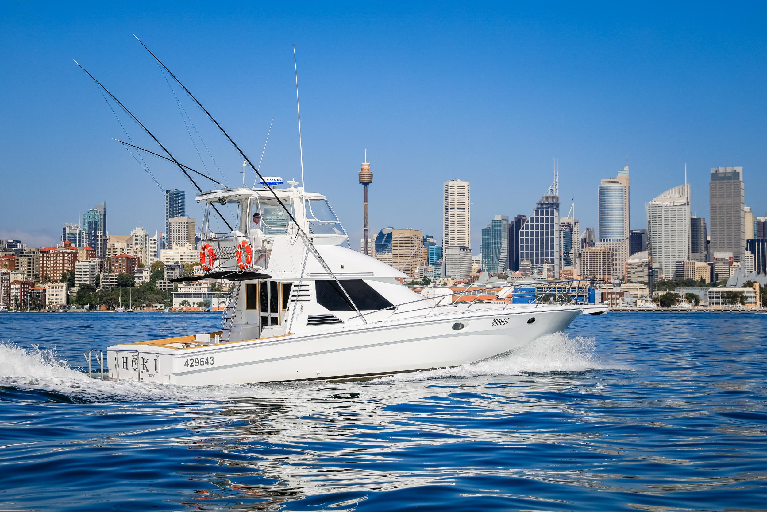 1993 Precision 47 Flybridge yacht cruising near city skyline on a sunny day.