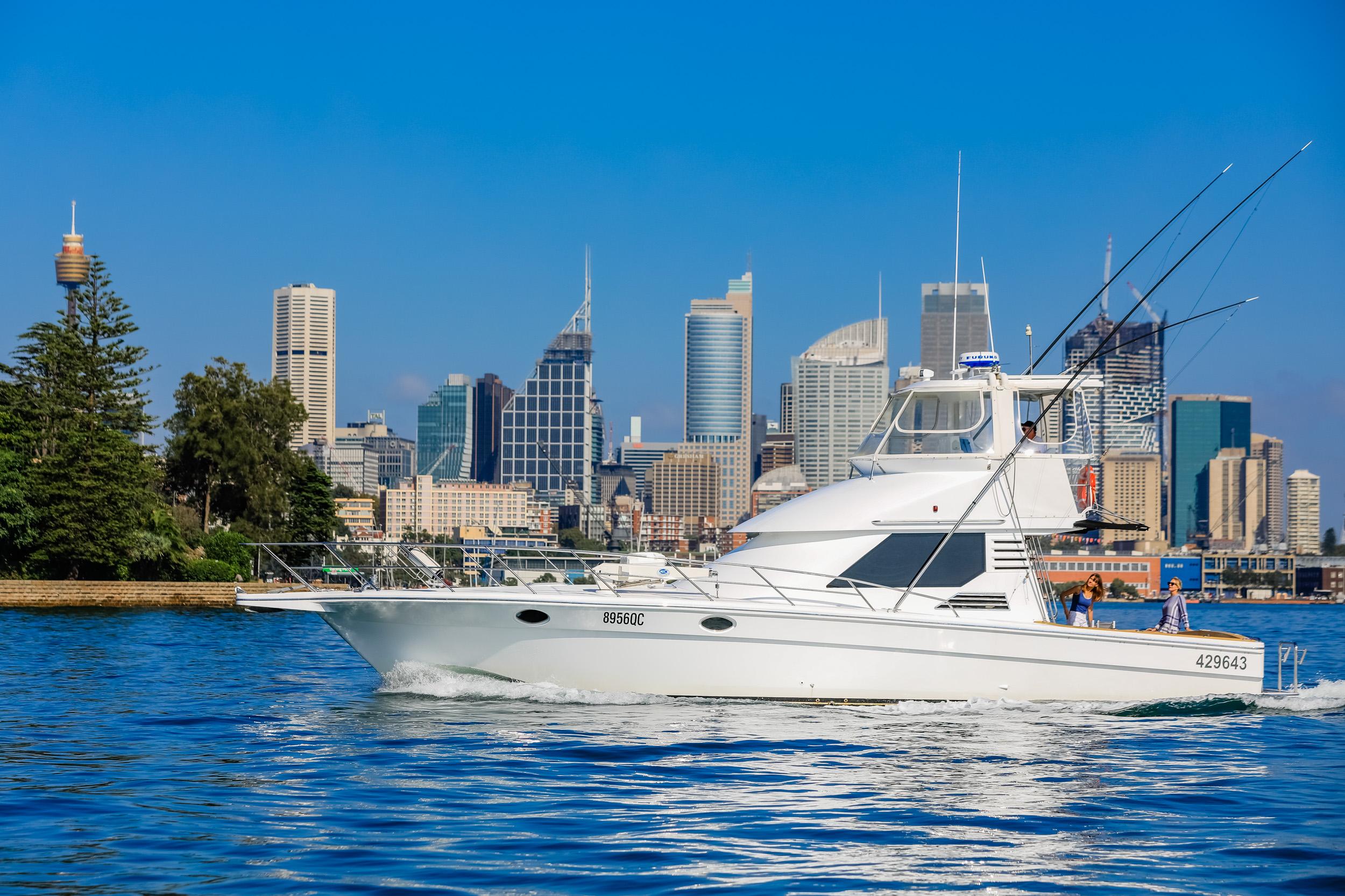 1993 Precision 47 Flybridge yacht cruising near city skyline on a sunny day.