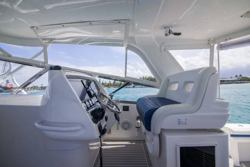 Sunkisser Yacht Photos Pics 2013 Intrepid 475 Sport Yacht cockpit with steering wheel and seating, overlooking ocean view.