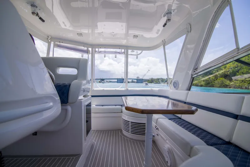 Sunkisser Yacht Photos Pics Interior of 2013 Intrepid 475 Sport Yacht with seating and table, overlooking water.