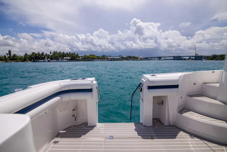 Sunkisser Yacht Photos Pics 2013 Intrepid 475 Sport Yacht on serene blue waters under a cloudy sky.