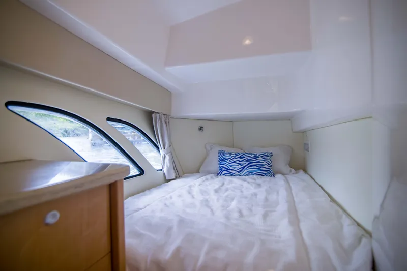 Sunkisser Yacht Photos Pics Cozy cabin interior of 2013 Intrepid 475 Sport Yacht with bed and decorative pillow.