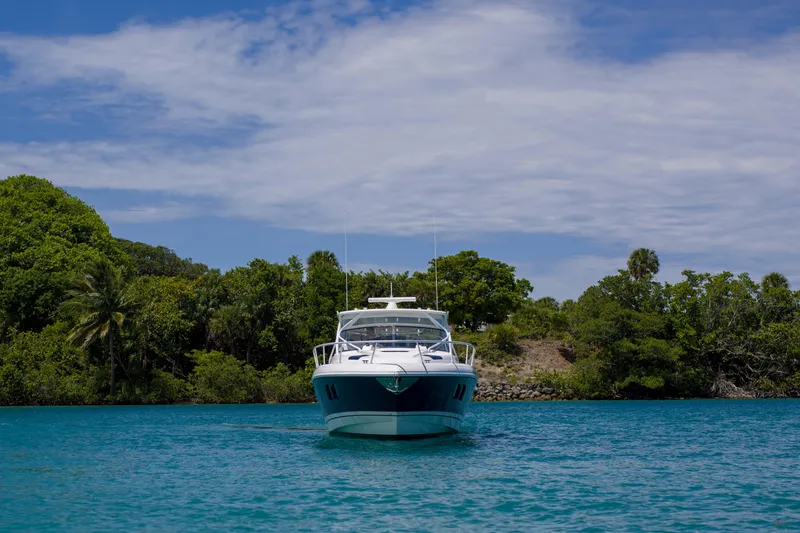 Sunkisser Yacht Photos Pics 2013 Intrepid 475 Sport Yacht on tranquil blue water, lush greenery background.