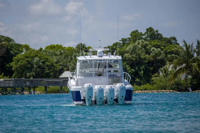 Sunkisser Yacht Photos Pics 2013 Intrepid 475 Sport Yacht cruising on blue water with lush greenery background.