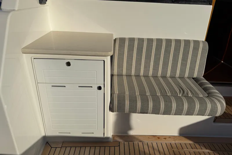  Yacht Photos Pics 2017 Grand Banks 44 Eastbay SX interior with striped seating and storage cabinet.