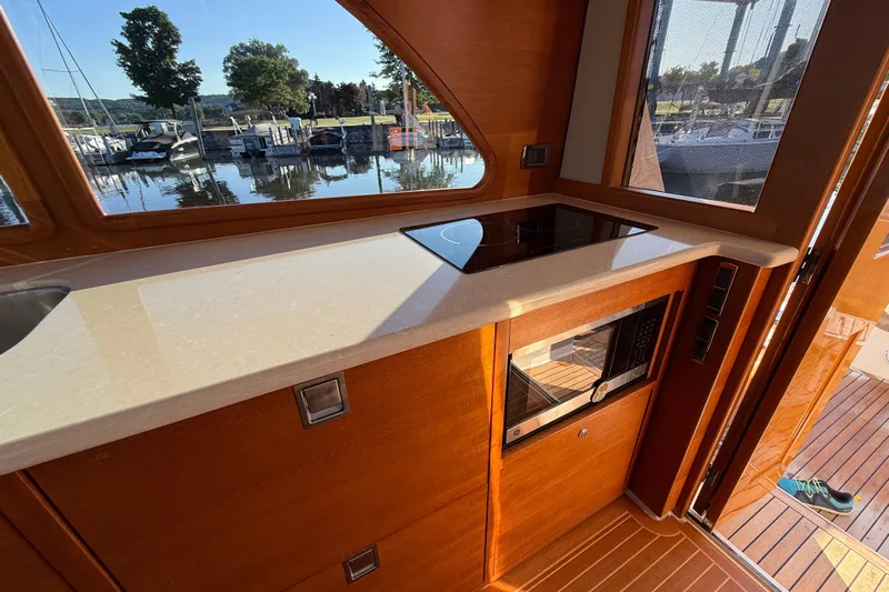  Yacht Photos Pics 2017 Grand Banks 44 Eastbay SX yacht interior with modern kitchen and scenic marina view.