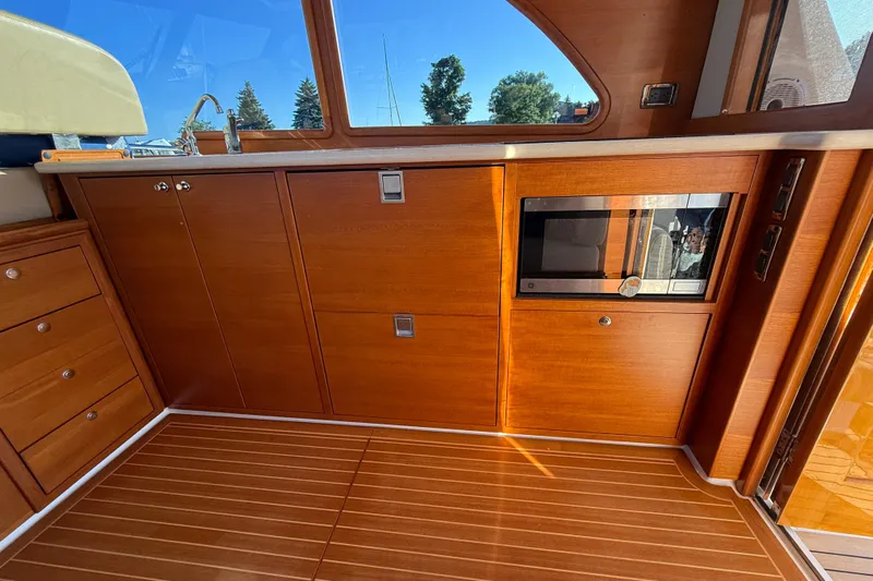 Yacht Photos Pics Interior of 2017 Grand Banks 44 Eastbay SX yacht with wooden cabinetry and modern appliances.