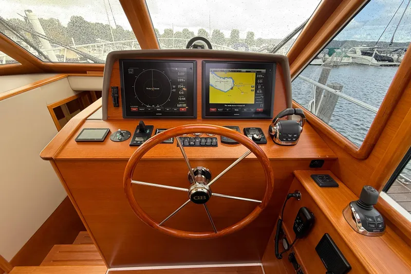  Yacht Photos Pics Helm of 2017 Grand Banks 44 Eastbay SX with navigation screens and wooden steering wheel.