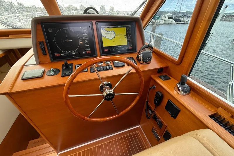  Yacht Photos Pics Helm of 2017 Grand Banks 44 Eastbay SX with navigation screens and wooden steering wheel.
