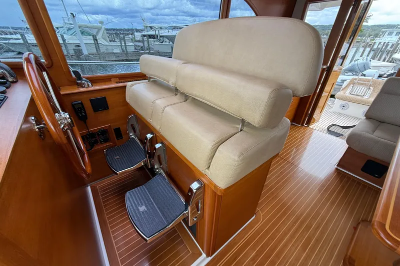  Yacht Photos Pics 2017 Grand Banks 44 Eastbay SX helm station with wooden wheel and cushioned seating.