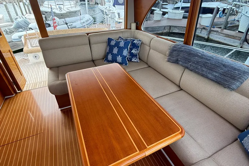  Yacht Photos Pics Luxurious interior of 2017 Grand Banks 44 Eastbay SX yacht with elegant seating and wooden table.
