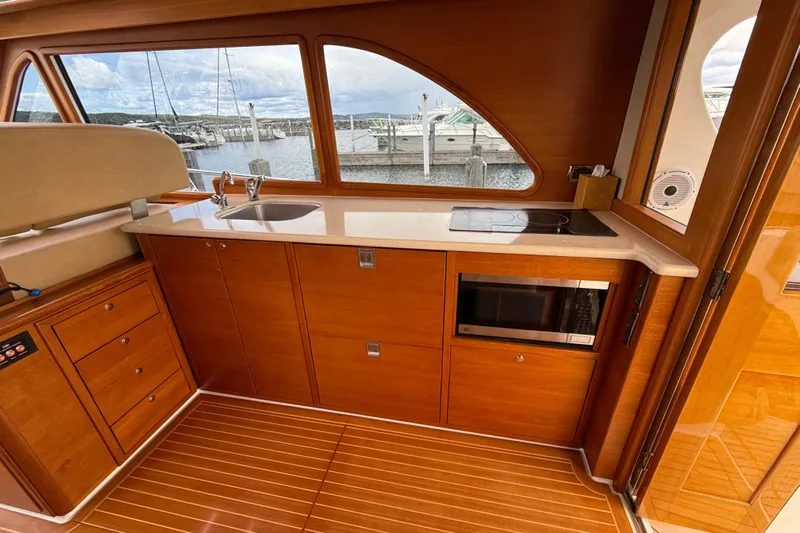  Yacht Photos Pics 2017 Grand Banks 44 Eastbay SX yacht interior with wooden cabinetry, sink, and microwave.