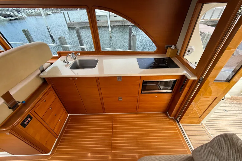  Yacht Photos Pics 2017 Grand Banks 44 Eastbay SX yacht interior with modern kitchen and wooden flooring.
