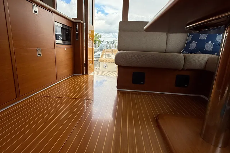  Yacht Photos Pics Interior of 2017 Grand Banks 44 Eastbay SX yacht with wooden flooring and cozy seating.