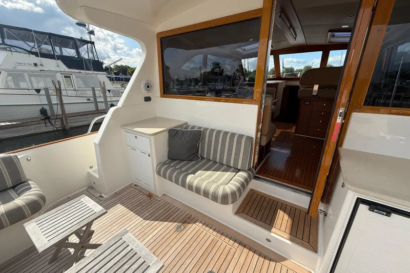  Yacht Photos Pics 2017 Grand Banks 44 Eastbay SX yacht interior with striped seating and wooden flooring.