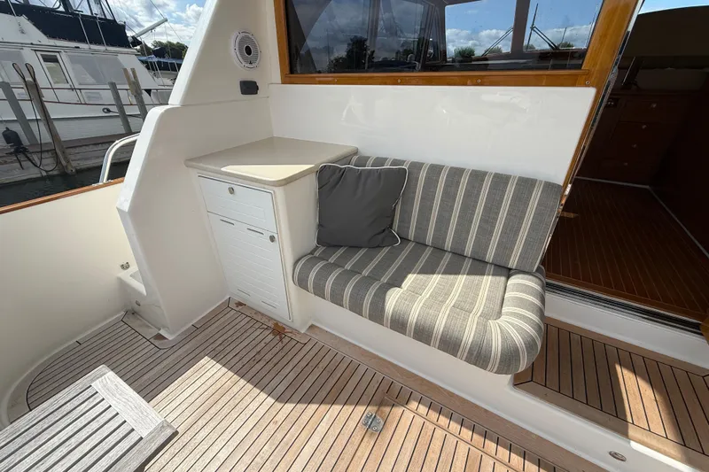  Yacht Photos Pics 2017 Grand Banks 44 Eastbay SX yacht with striped seating and wooden deck.