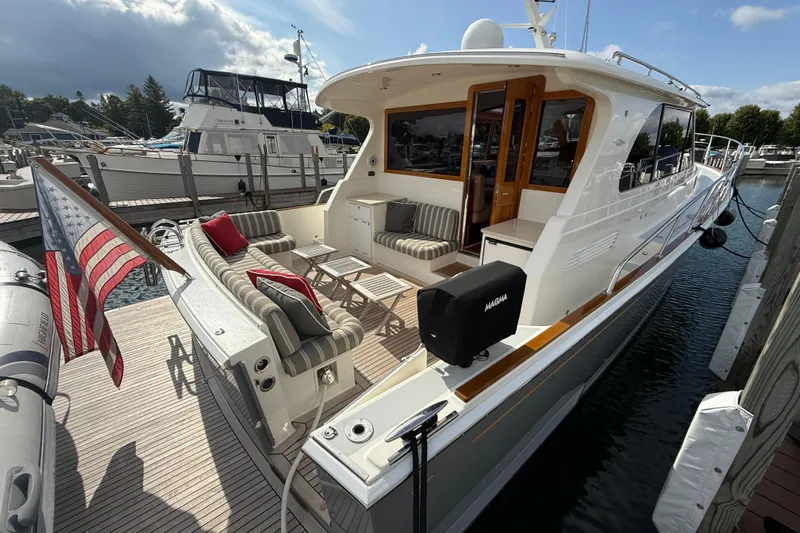  Yacht Photos Pics 2017 Grand Banks 44 Eastbay SX yacht docked, featuring elegant seating and American flag.