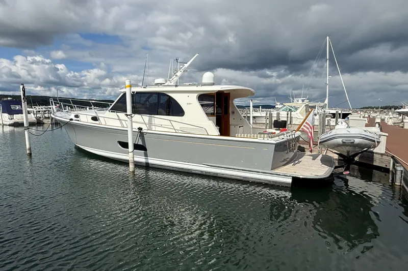  Yacht Photos Pics 2017 Grand Banks 44 Eastbay SX yacht docked at marina under cloudy sky.