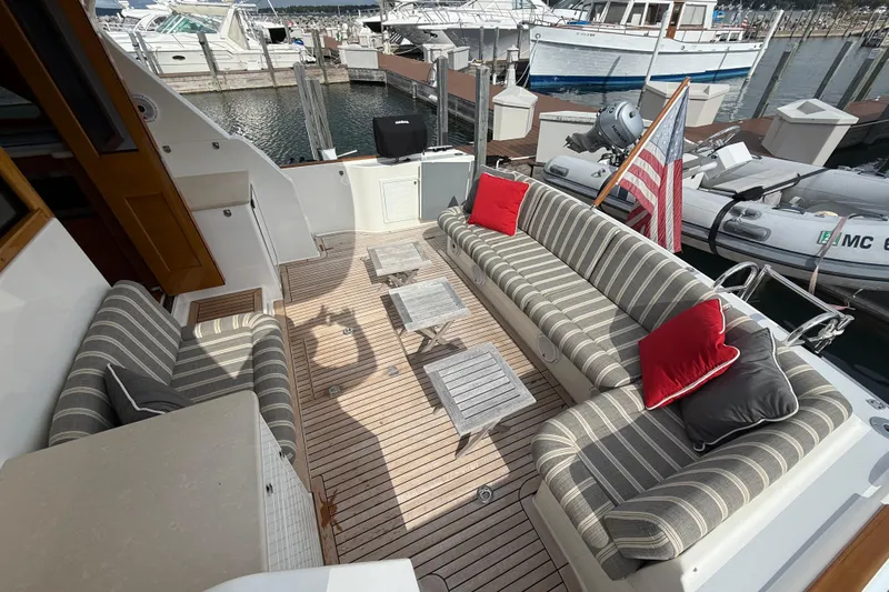  Yacht Photos Pics Luxurious 2017 Grand Banks 44 Eastbay SX yacht deck with striped seating and American flag.
