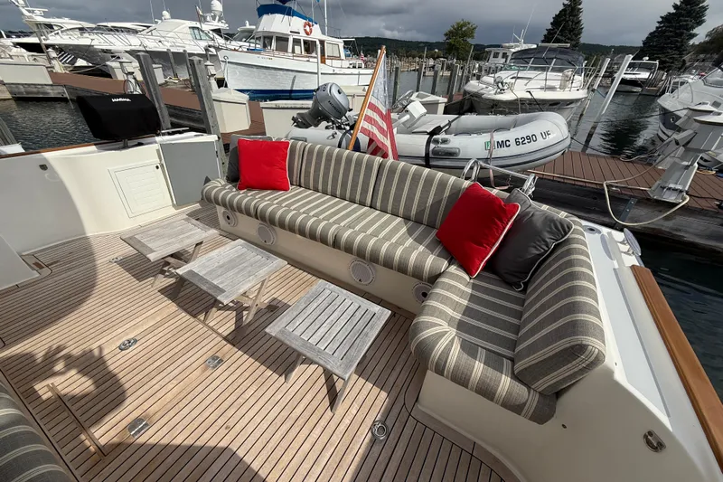  Yacht Photos Pics 2017 Grand Banks 44 Eastbay SX yacht with striped seating, red cushions, and wooden deck.