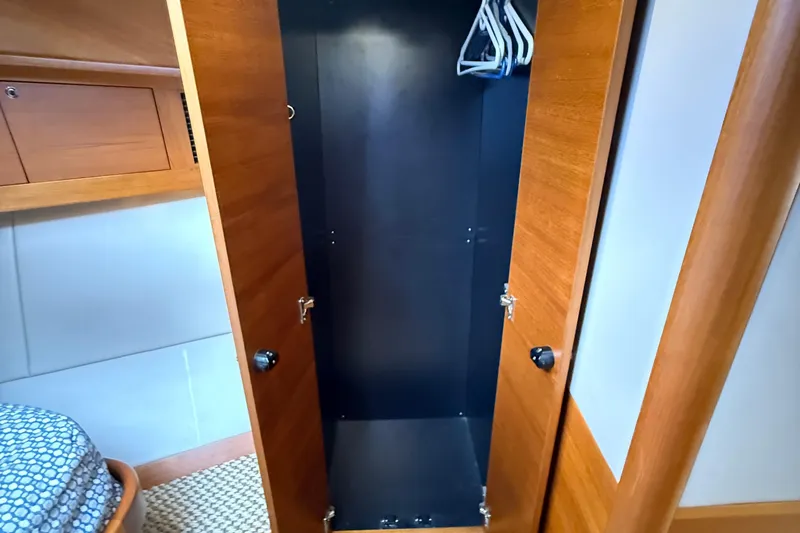  Yacht Photos Pics Wooden closet interior on 2017 Grand Banks 44 Eastbay SX yacht, featuring hangers and storage space.
