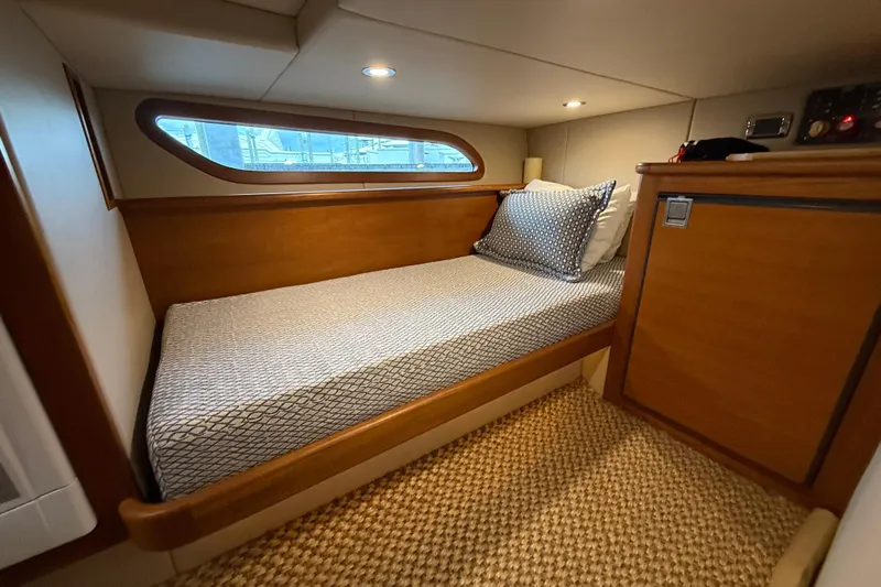  Yacht Photos Pics Cozy cabin interior of 2017 Grand Banks 44 Eastbay SX with wooden finish and bed.