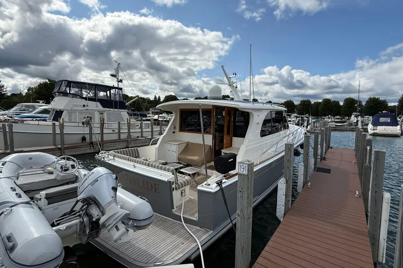  Yacht Photos Pics 2017 Grand Banks 44 Eastbay SX yacht docked at marina under cloudy sky.