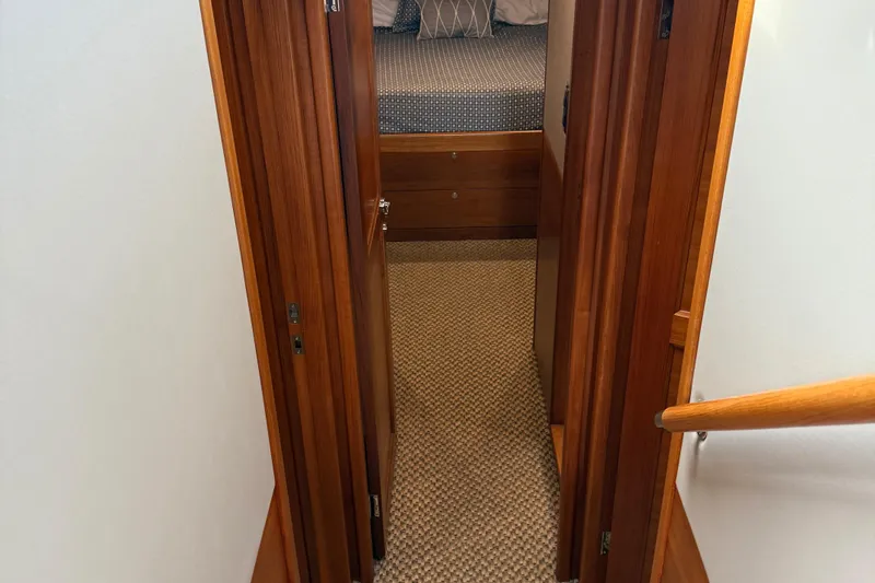  Yacht Photos Pics Interior hallway of 2017 Grand Banks 44 Eastbay SX yacht with wooden doors and carpet.