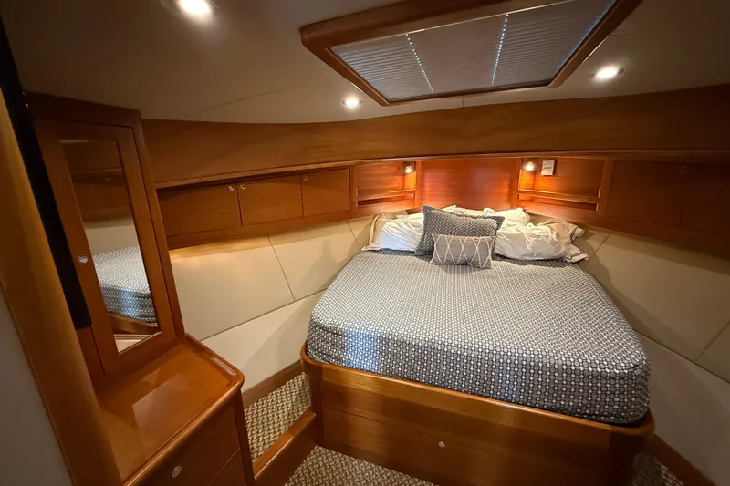  Yacht Photos Pics Luxurious cabin interior of 2017 Grand Banks 44 Eastbay SX yacht, featuring cozy bedding and wood finishes.