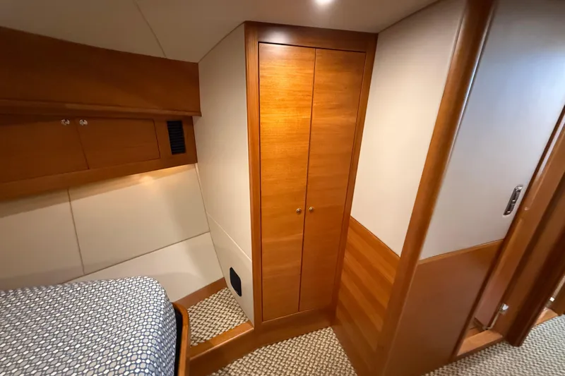  Yacht Photos Pics 2017 Grand Banks 44 Eastbay SX cabin interior with wooden closet and bed.